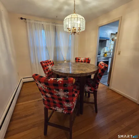 a dining room with furniture a chandelier and wooden floor