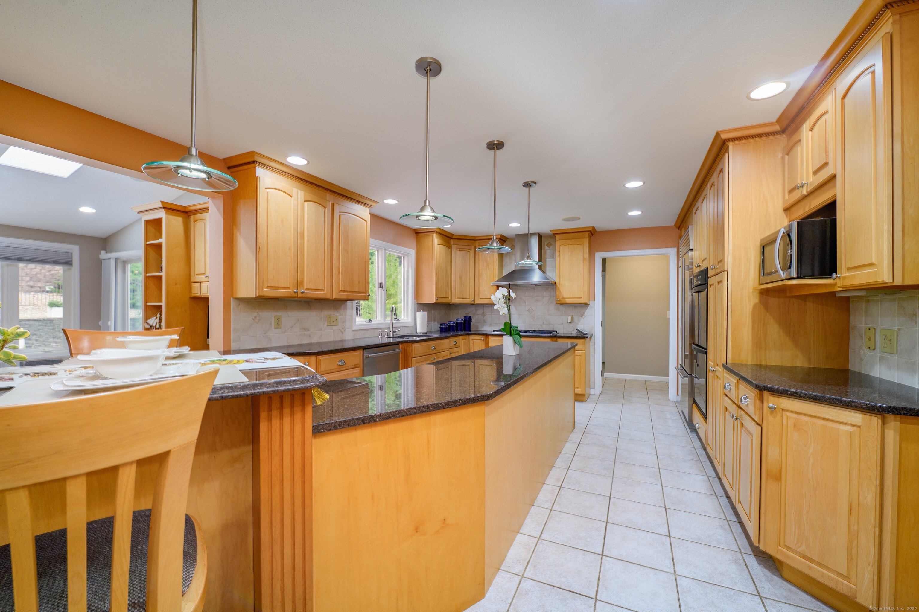85 Inverness Court Cheshire, CT 06410 - Photo 8 of 40 a large kitchen with kitchen island a large counter top a stove a sink and a refrigerator