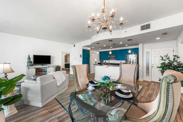 a living room with furniture kitchen view and a wooden floor