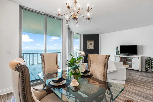 a living room with furniture a flat screen tv and a floor to ceiling window