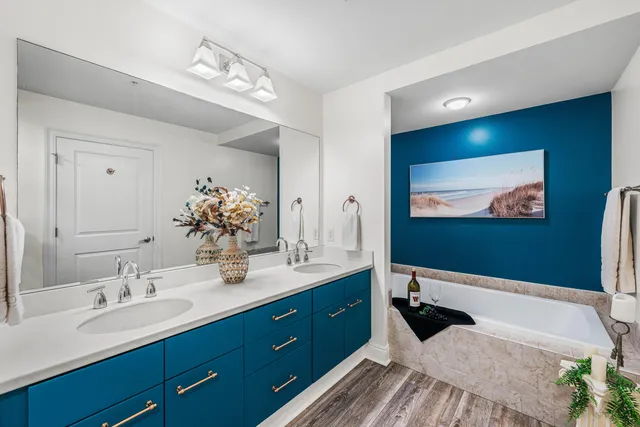 a spacious bathroom with a double vanity sink a large mirror and a shower