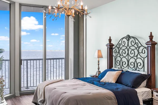 a bedroom with a large bed and a chandelier