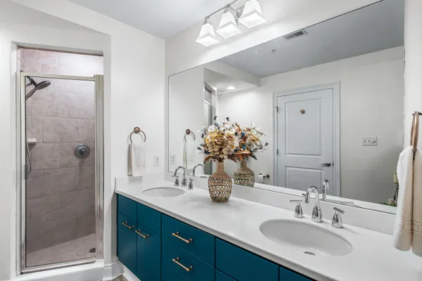 a bathroom with a double vanity sink mirror and shower