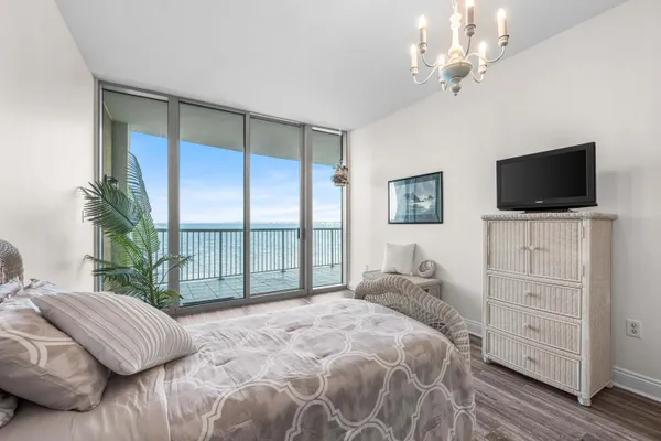 a bedroom with a large bed and a flat tv screen on dresser