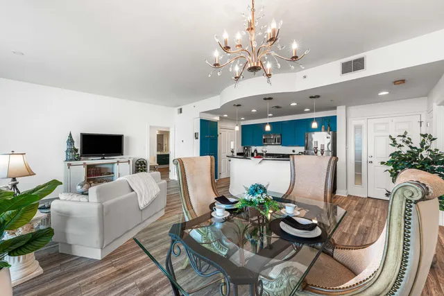 a living room with furniture kitchen view and a wooden floor