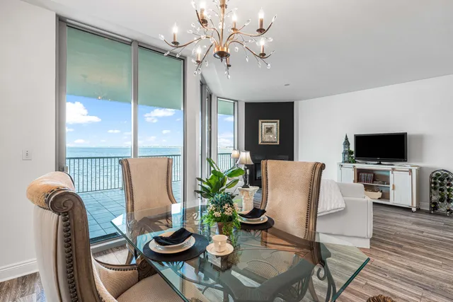 a living room with furniture a flat screen tv and a floor to ceiling window