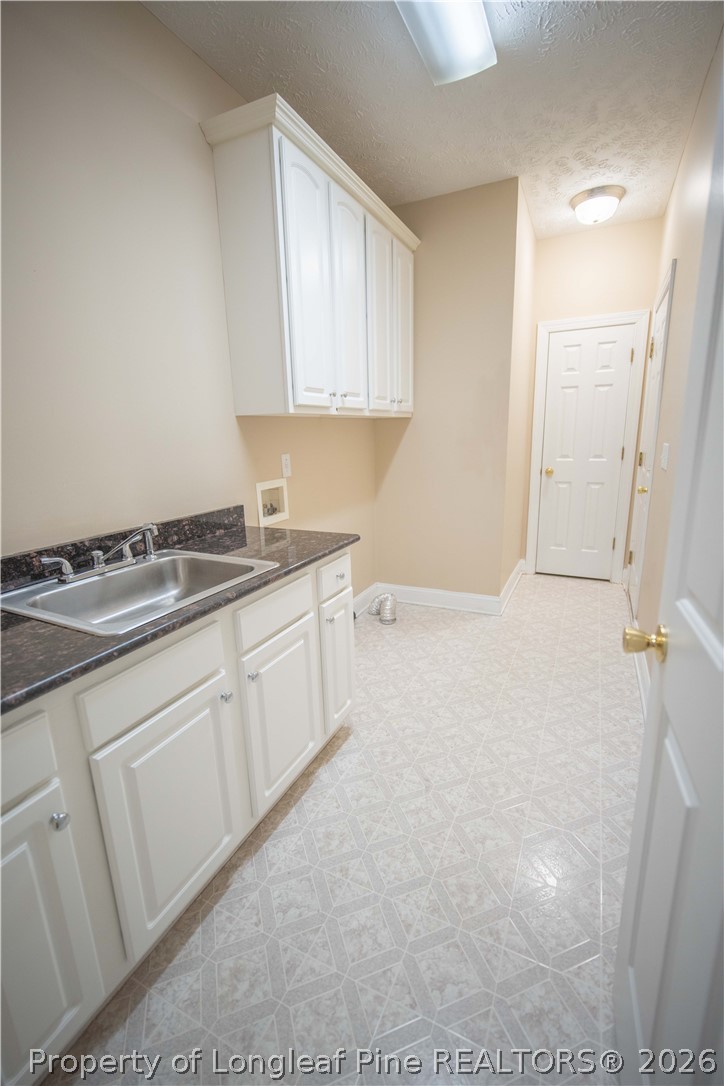 6826 Surrey Road Fayetteville, NC 28306 - Photo 14 of 50 a kitchen with granite countertop white cabinets and white appliances