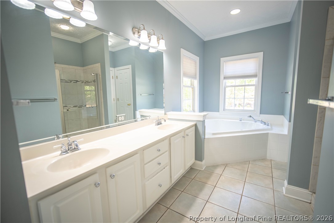 6826 Surrey Road Fayetteville, NC 28306 - Photo 27 of 50 a bathroom with a double vanity sink a mirror and a bathtub