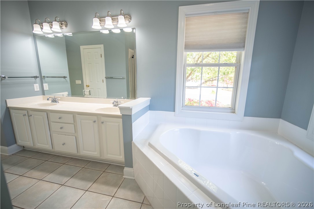 6826 Surrey Road Fayetteville, NC 28306 - Photo 29 of 50 a spacious bathroom with a bathtub sink and a mirror