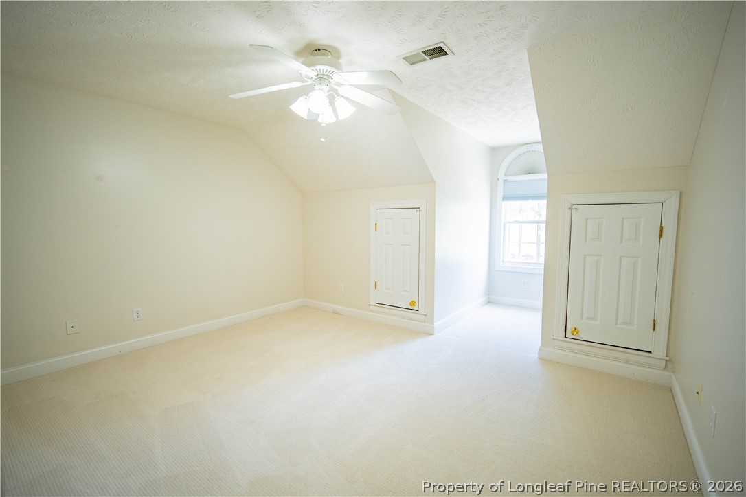 6826 Surrey Road Fayetteville, NC 28306 - Photo 38 of 50 en empty room with windows and chandelier fan