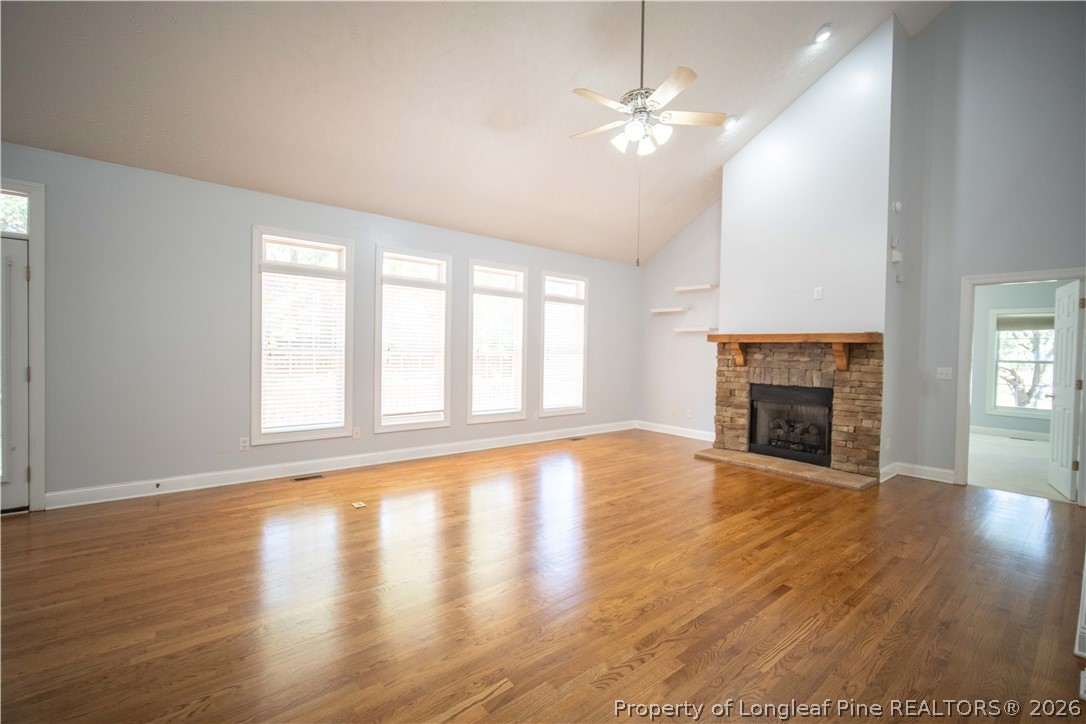 6826 Surrey Road Fayetteville, NC 28306 - Photo 10 of 50 an empty room with wooden floor fireplace and windows