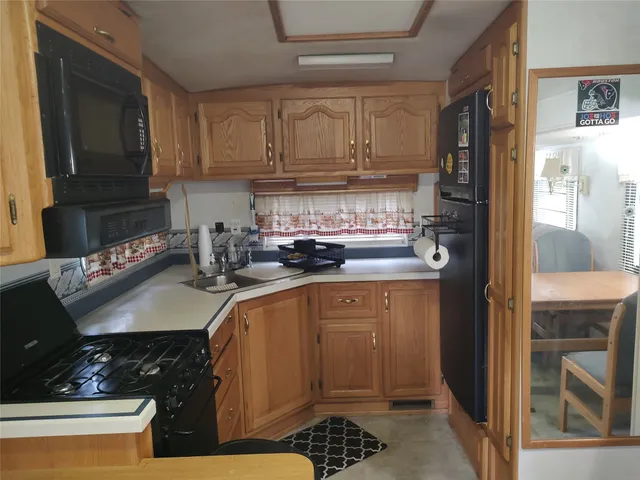 a kitchen with stainless steel appliances granite countertop a refrigerator stove and sink