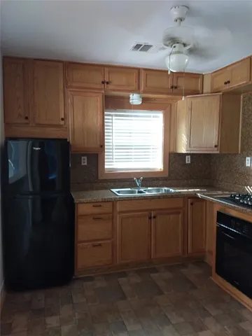 a kitchen with granite countertop white cabinets and black appliances