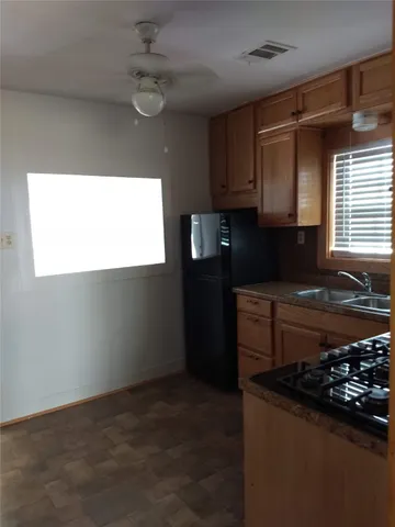 a kitchen with granite countertop a sink stainless steel appliances and cabinets