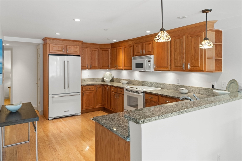 60 Merrimac Street, Unit 907 Amesbury, MA 01913 - Photo 12 of 23 a kitchen with granite countertop a sink and refrigerator