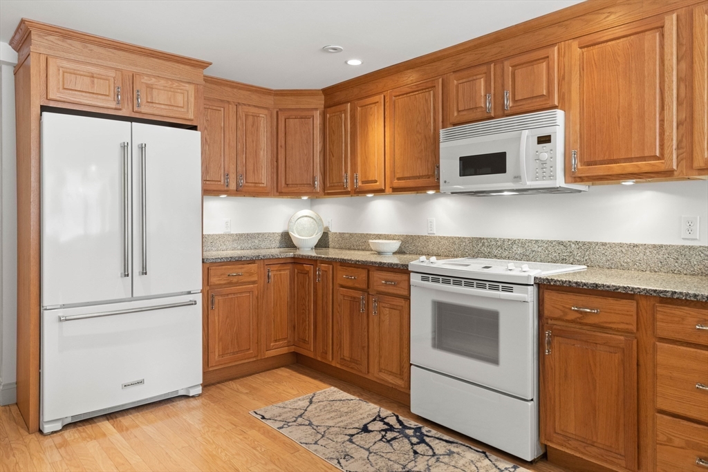 60 Merrimac Street, Unit 907 Amesbury, MA 01913 - Photo 14 of 23 a kitchen with stainless steel appliances granite countertop a refrigerator sink and cabinets