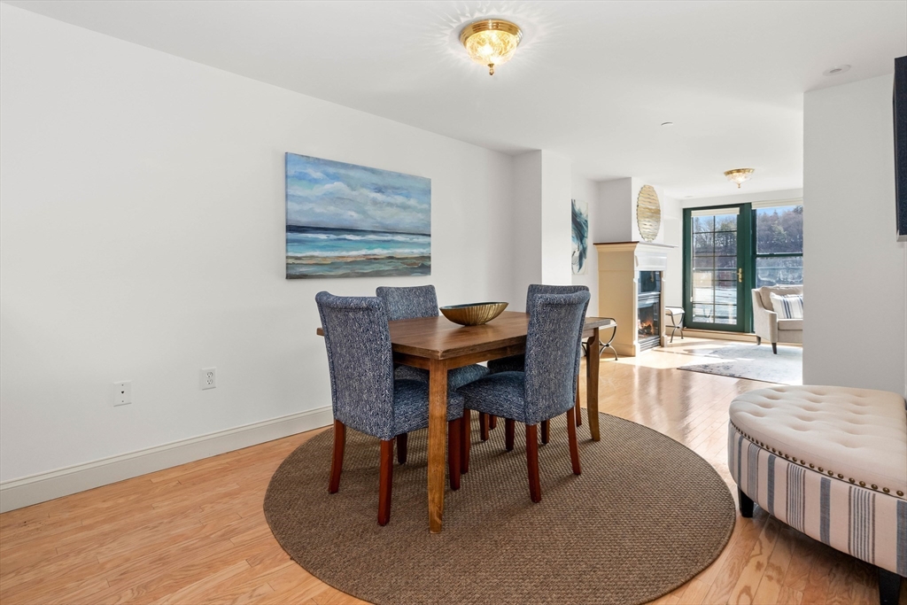 60 Merrimac Street, Unit 907 Amesbury, MA 01913 - Photo 15 of 23 a dining room with furniture a rug and wooden floor