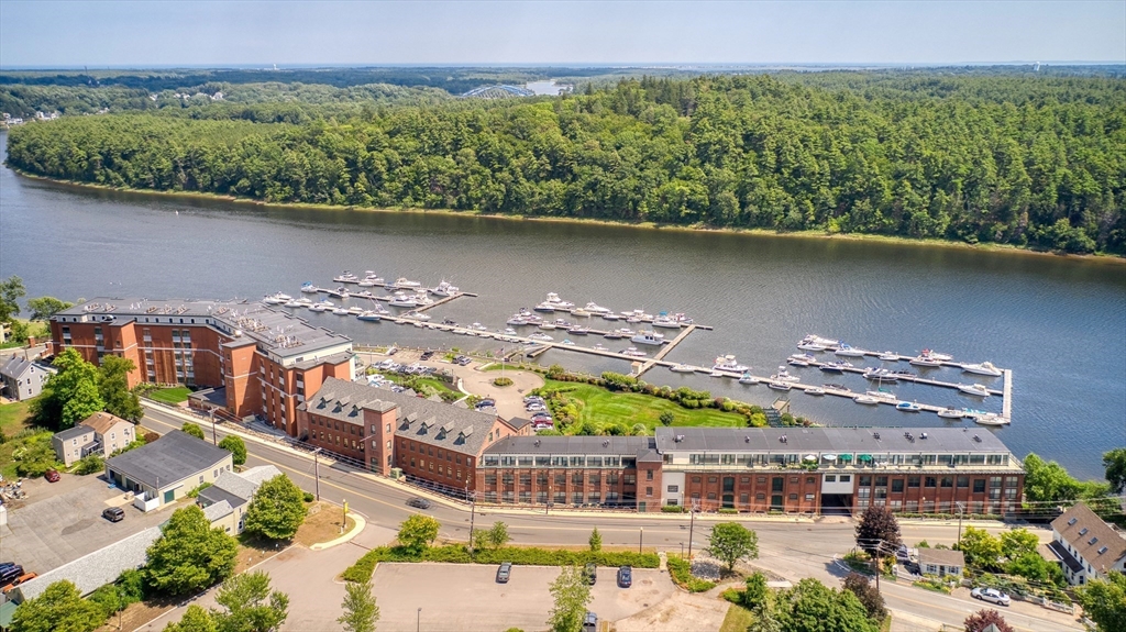 60 Merrimac Street, Unit 907 Amesbury, MA 01913 - Photo 2 of 23 an aerial view of a building with garden space and outdoor seating