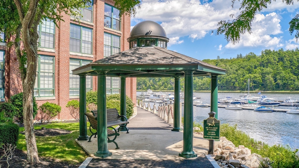 60 Merrimac Street, Unit 907 Amesbury, MA 01913 - Photo 22 of 23 a view of a brick house with a large windows next to a yard