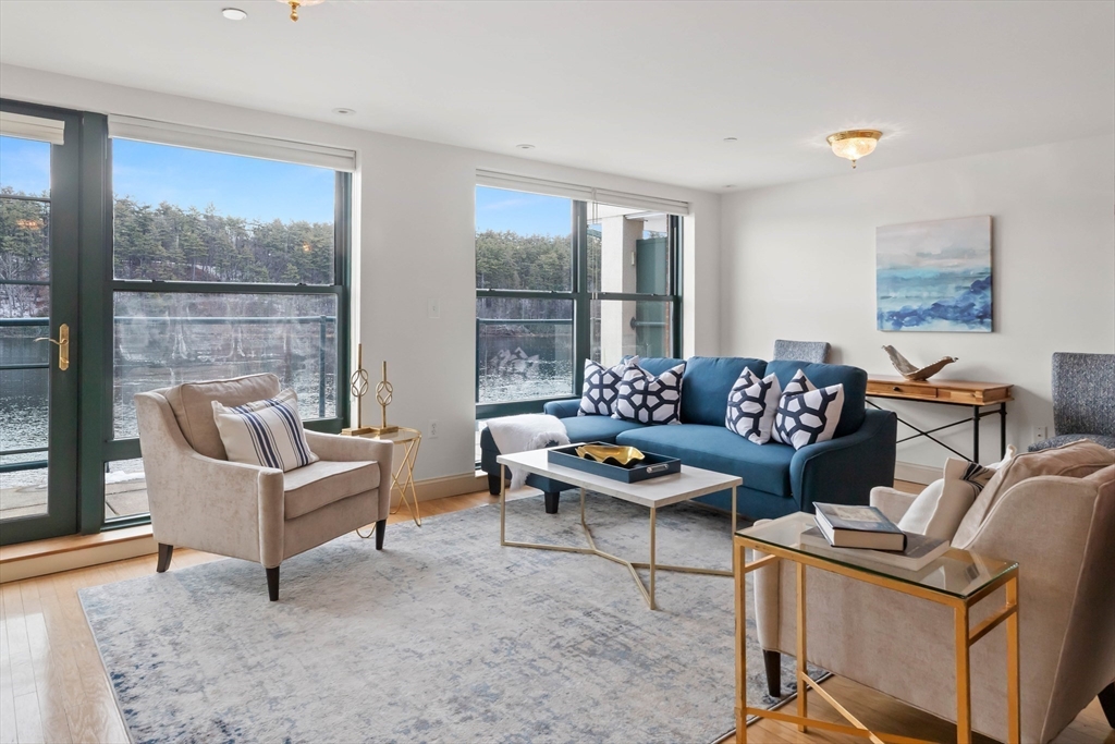 60 Merrimac Street, Unit 907 Amesbury, MA 01913 - Photo 5 of 23 a living room with furniture and a floor to ceiling window
