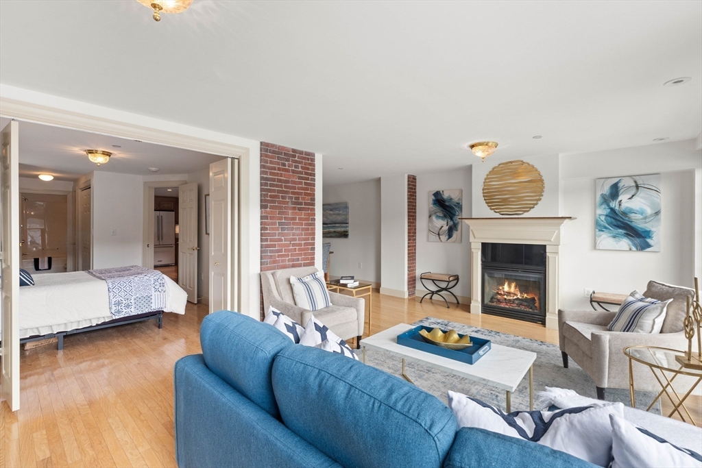 60 Merrimac Street, Unit 907 Amesbury, MA 01913 - Photo 6 of 23 a living room with furniture and a fireplace