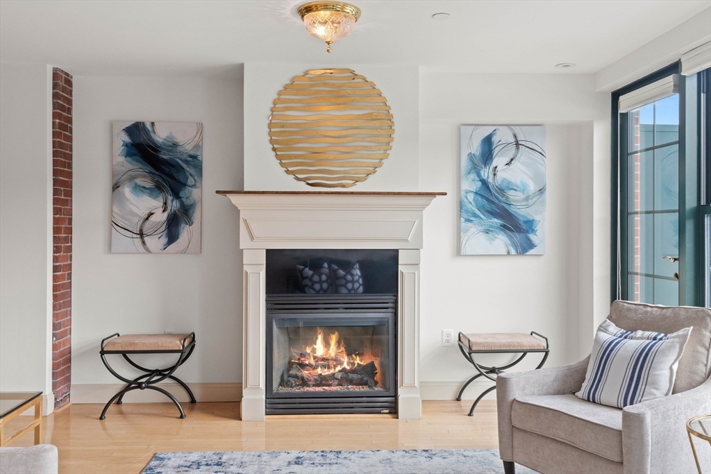 60 Merrimac Street, Unit 907 Amesbury, MA 01913 - Photo 8 of 23 a living room with furniture and a fireplace