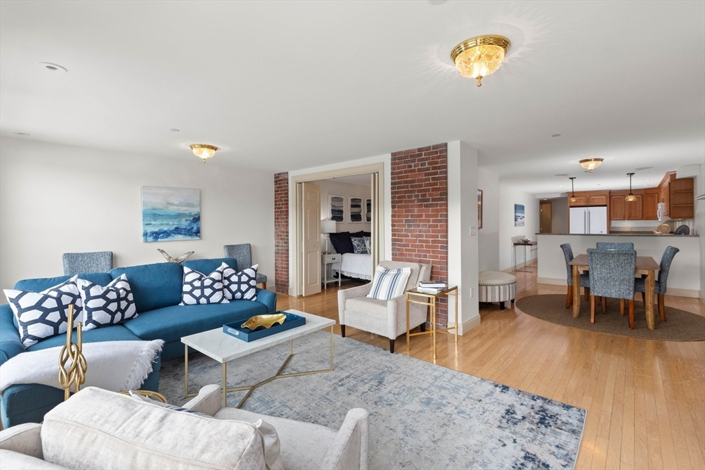 60 Merrimac Street, Unit 907 Amesbury, MA 01913 - Photo 10 of 23 a living room with furniture and a wooden floor