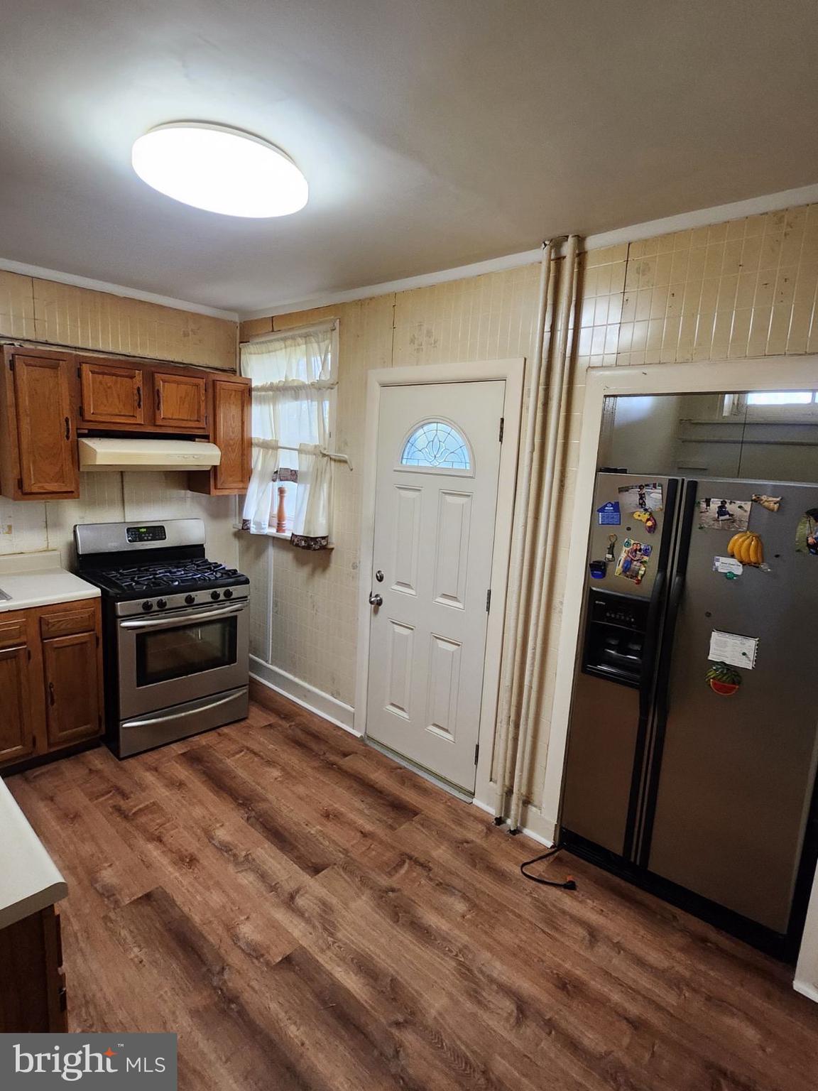 a kitchen with granite countertop a refrigerator and a stove top oven