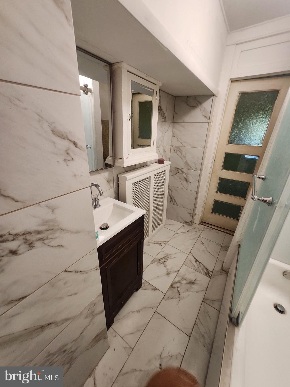 69 South 7th Street Darby, PA 19023 - Photo 14 of 17 a bathroom with a sink a mirror and bathtub