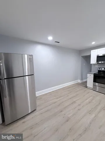a kitchen with wooden floors and white stainless steel appliances