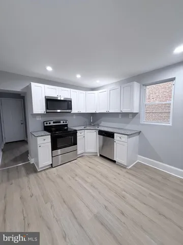 a kitchen with granite countertop a stove a sink and a refrigerator