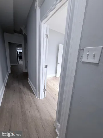 a view of a hallway with wooden floor and a living room