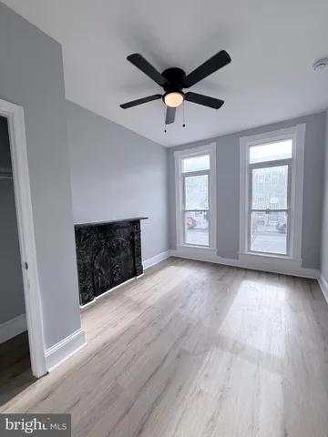 an empty room with windows and fireplace