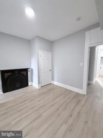 a view of an empty room with wooden floor and cabinet