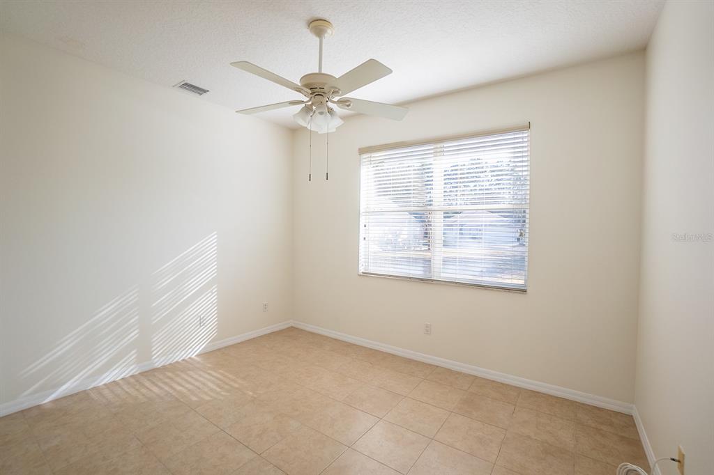 107 Raintree Circle Palm Coast, FL 32164 - Photo 17 of 46 an empty room with a window and a fan