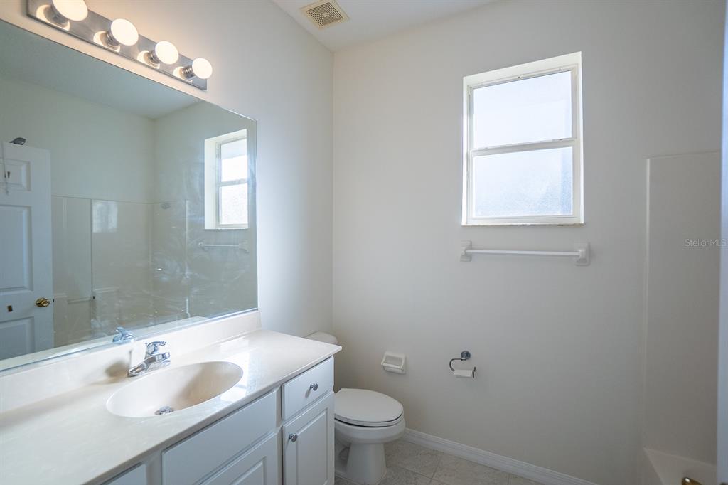 107 Raintree Circle Palm Coast, FL 32164 - Photo 19 of 46 a bathroom with a granite countertop sink a toilet and a mirror