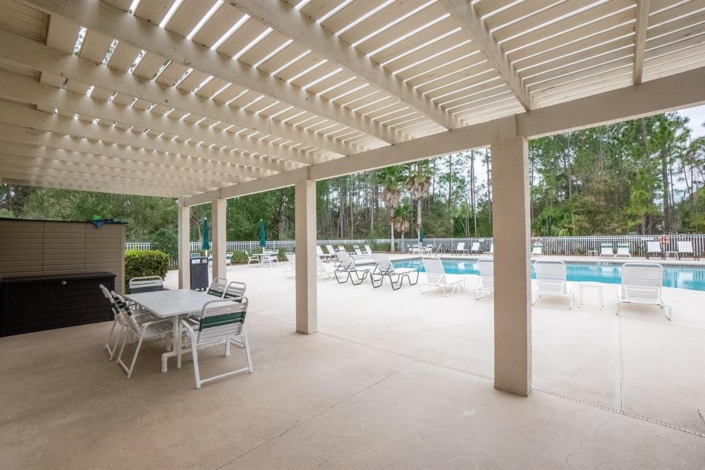 107 Raintree Circle Palm Coast, FL 32164 - Photo 23 of 46 a dining room with furniture and a garden view