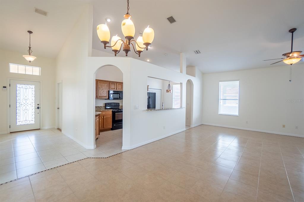 107 Raintree Circle Palm Coast, FL 32164 - Photo 31 of 46 an empty room with chandelier wooden floor and windows