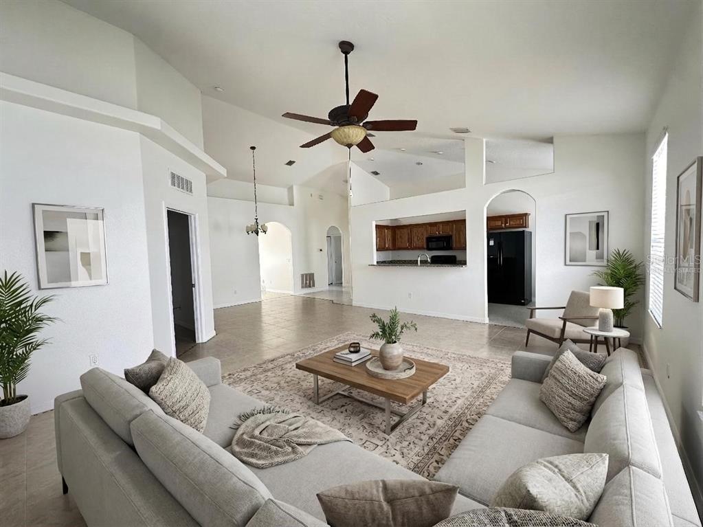 107 Raintree Circle Palm Coast, FL 32164 - Photo 4 of 46 a living room with furniture kitchen view and a chandelier