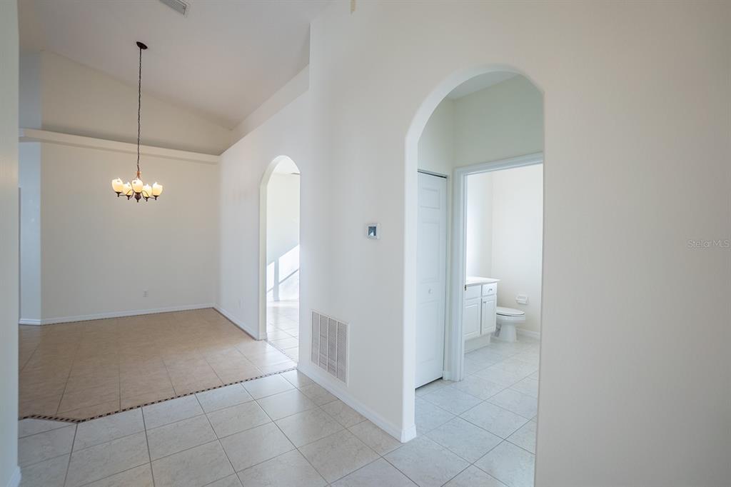 107 Raintree Circle Palm Coast, FL 32164 - Photo 10 of 46 a view of a room with wooden floor and a ceiling fan