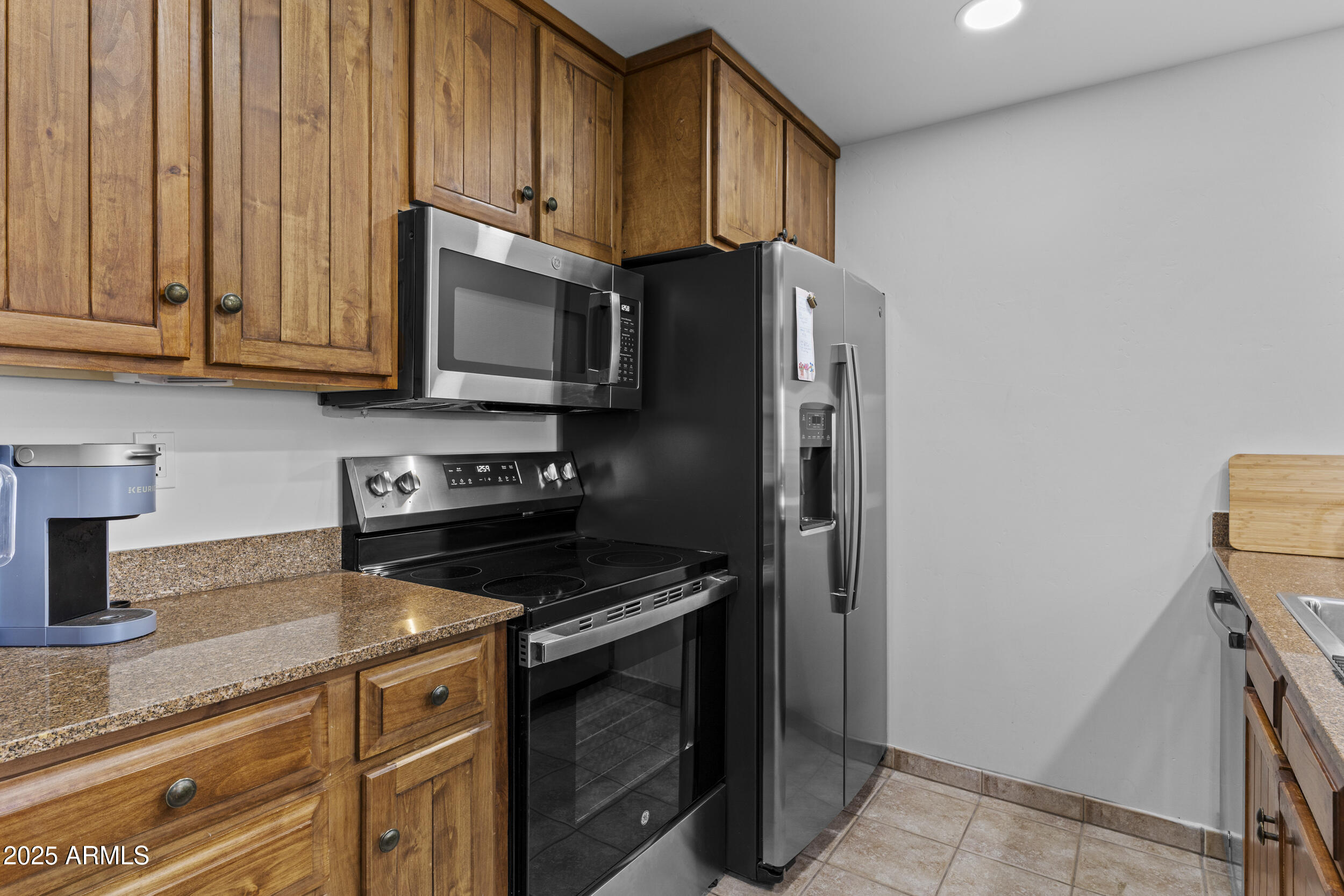 36601 North Mule Train Road, Unit D18 Carefree, AZ 85377 - Photo 5 of 53 a kitchen with granite countertop a refrigerator stove and microwave