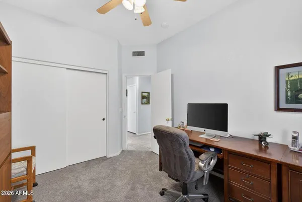 a view of a workspace with furniture and a window