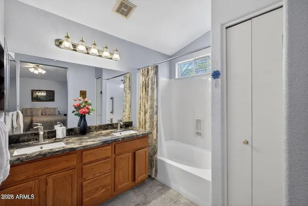 a bathroom with a tub a double vanity sink and a mirror
