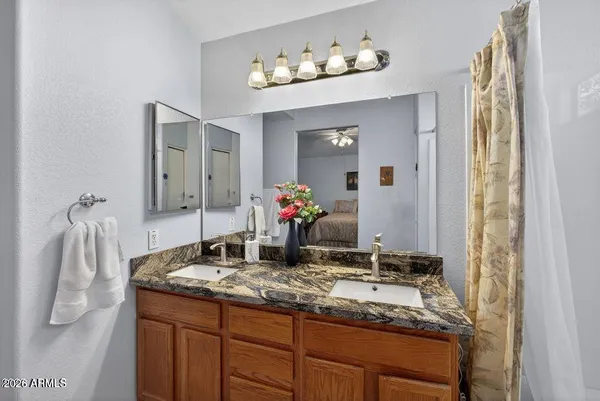 a bathroom with a granite countertop sink and a mirror