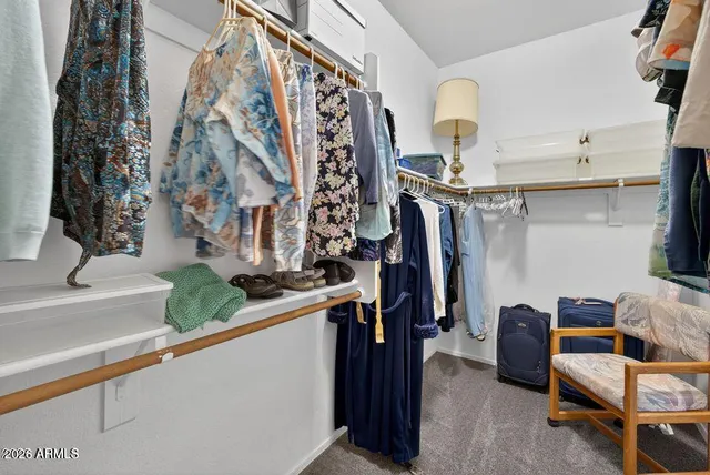 a view of walk in closet with clothes and shoes