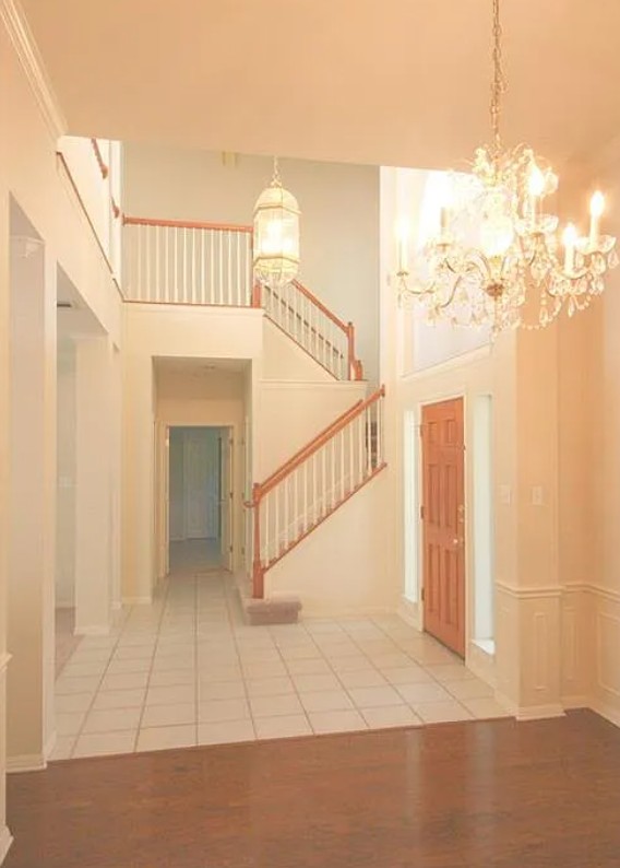 9405 Ashton Ridge Austin, TX 78750 - Photo 12 of 22 A grand two-story entryway welcomes with an elegant chandelier and rich wood and tile flooring.