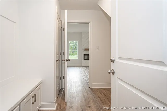 a view of a hallway with wooden floor and staircase