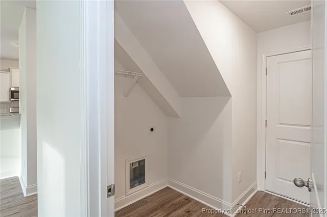 a view of a hallway with wooden floor and entryway