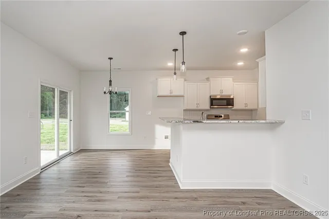 a view of kitchen with kitchen island wooden floor wooden floor and window