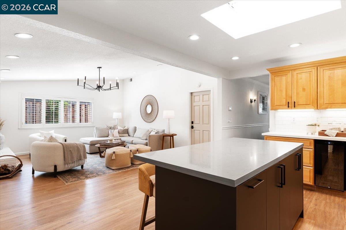 4175 Pickwick Drive Concord, CA 94521 - Photo 20 of 41 a open kitchen with stainless steel appliances granite countertop a stove top oven a couches and a dining table with wooden floor
